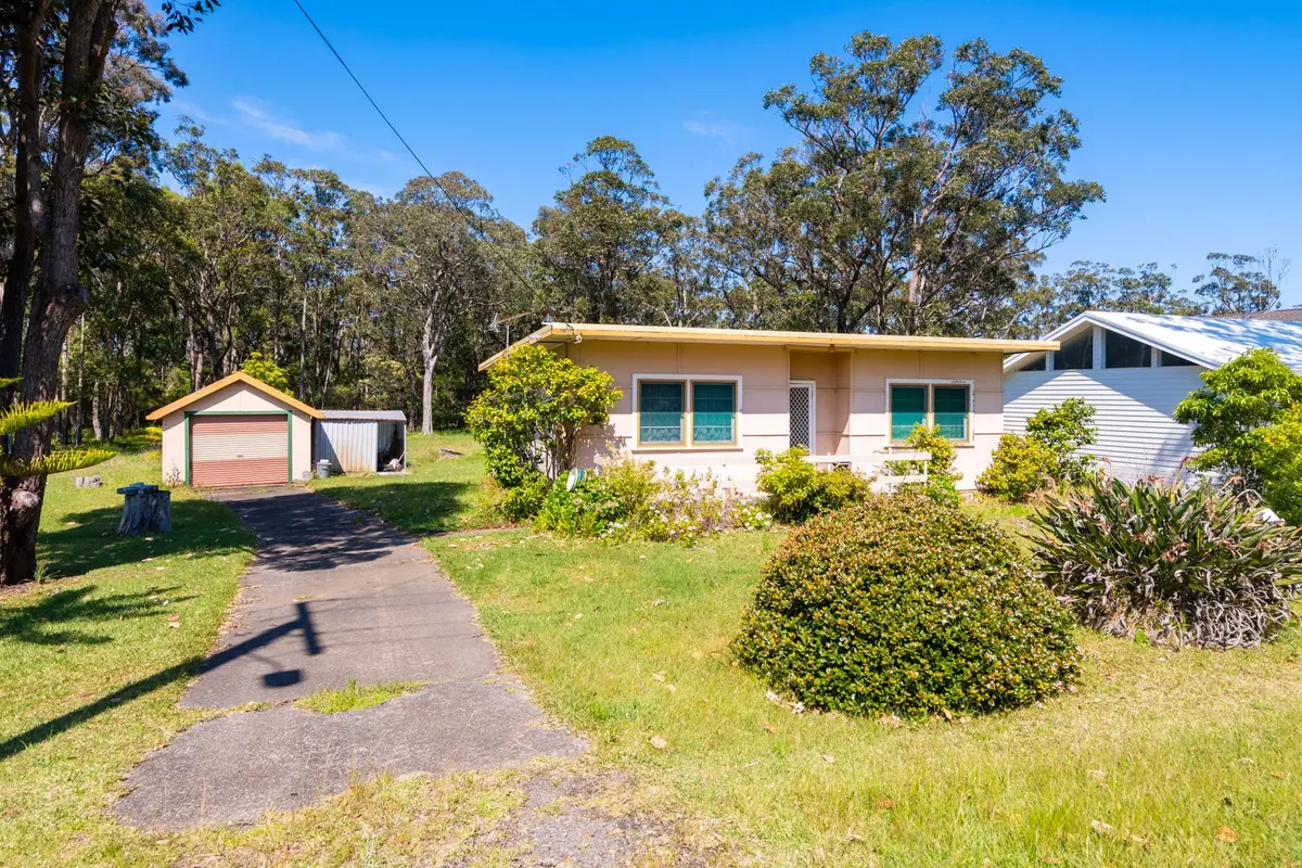 Before: a small flat-roofed cottage with a detached garage on a bush block at Huskisson
